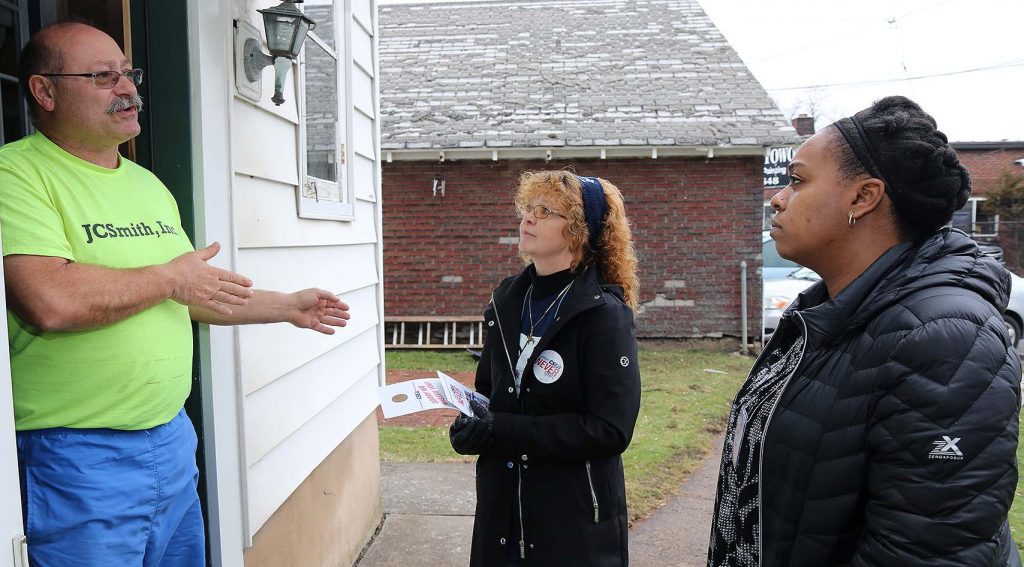 State Department of Transportation worker Richard Dobrodziej has a conversation in the doorway of his Utica home with Oneida Local President Denise Golden and CSEA Statewide Organizer April Land.