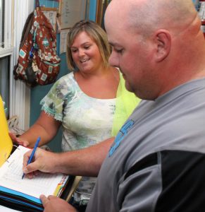 Impeccable record keeping is a requirement for child care providers. Here, Brandt has a parent sign paperwork.