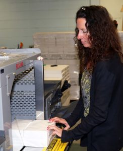 Lori Cossack binds papers at the Pak-Tyer machine.