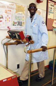 Patrick Duke demonstrating a treadmill he uses to help his patients.