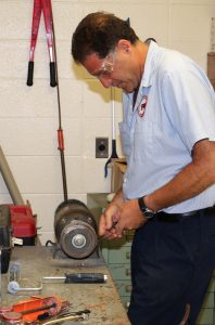 Sal Lombardo sharpens a scraper at the custodial office in South Ocean Middle School.