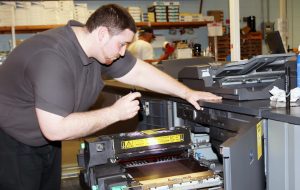 Mike Miller investigates a problem with a copy machine.