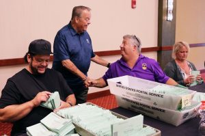 CSEA President Danny Donohue, standing in center, greets State Negotiating Team members Howard Crawford, left, and Matt Greenhouse. Donohue came to give his support and appreciation to the team members as they counted ballots.