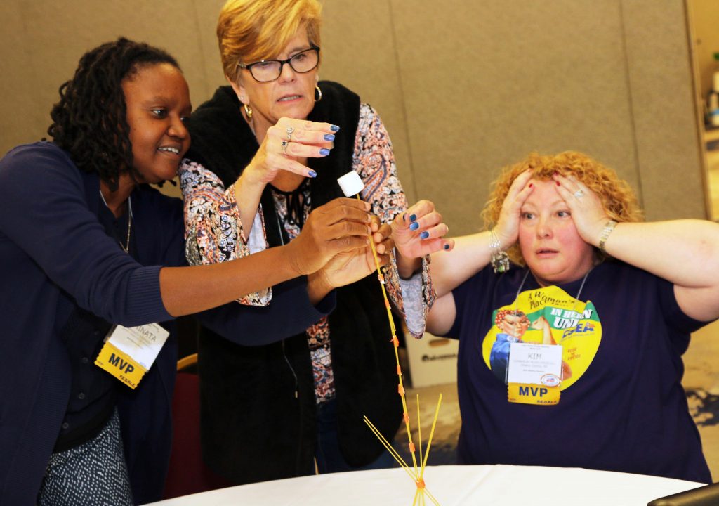 During an organizing workshop at the 107th Annual Delegates Meeting, from left, CSEA Deputy Director of Organizing Aminata Stephens, state Department of Motor Vehicles Local President Cindy Stiles and state Department of Motor Vehicles Local 1st Vice President Kim Ruso-Driscoll work together on the Marshmallow Challenge. The idea of the teamwork exercise is to build the tallest structure out of spaghetti and tape that can support the weight of a marshmallow at the top. With moments to go, the group’s structure was having difficulty standing up.