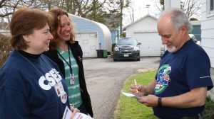 In this 2016 file photo, Herkimer County Local President Beth Hall, left, and CSEA Organizer Mandy Ellis speak with Onondaga County Department of Water Environment Protection Unit President Rob Sweeney outside his East Syracuse home.