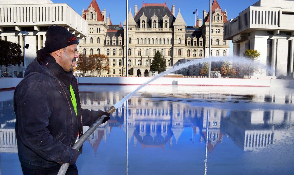 Stan Greer, a general mechanic at the state Office of General Services, sprays water onto the ice rink at the Empire State Plaza in Albany to prepare for the rink’s opening for the winter season. Greer and his co-workers play key roles in ensuring that plaza events such as ice skating, Capitol tours and special events run smoothly, keeping state facilities in top condition and much more. (Photo by John Carl D’Annibale, Times Union)