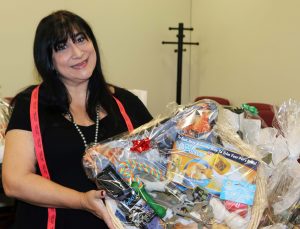Donna Huebner proudly showcases the basket she won at the auction.
