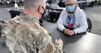 Donald Grove, right, an opioid data coordinator for the Office of Drug User Health, analyzes and provides critical real time data on New York’s vast vaccination program from a command hub at the Javits Convention Center.