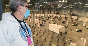 Donald Grove, an opioid data coordinator for the state Office of Drug User Health, looks down at the vast space that is being used for COVID-19 vaccinations at the Javits Convention Center in Manhattan, which is one of the state’s vaccination hubs. Read Page 3 for more about CSEA members’ efforts at the Javits Center, as well as more COVID-19 response coverage on Pages 5, 10-11. (Photo by David Galarza)