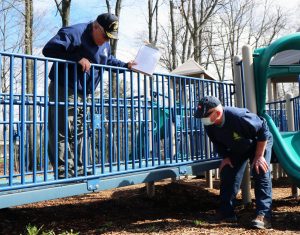 Barry Plumley and Jason Maroney inspect playground equipment at a Town of Ramapo park.