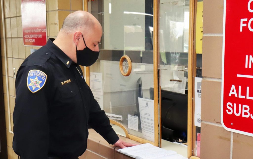 Marc Priore, a corrections officer at Erie County Correctional Facility, checks the log book.