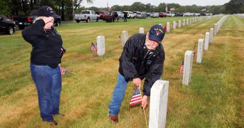 CSEA Long Island Region Veterans Committee Chair Maryann Phelps, left, salutes as committee member Steve Abramson plants a flag beside a gravesite at Calverton National Cemetery as part of the committee’s annual Memorial Day Flag Placement, when committee members, guests and community members place flags at the graves of CSEA affiliated individuals who served in the Armed Forces.