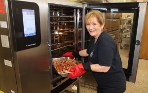 Deborah Dempsey removes lunch from oven