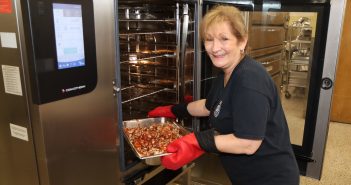 Deborah Dempsey removes lunch from oven