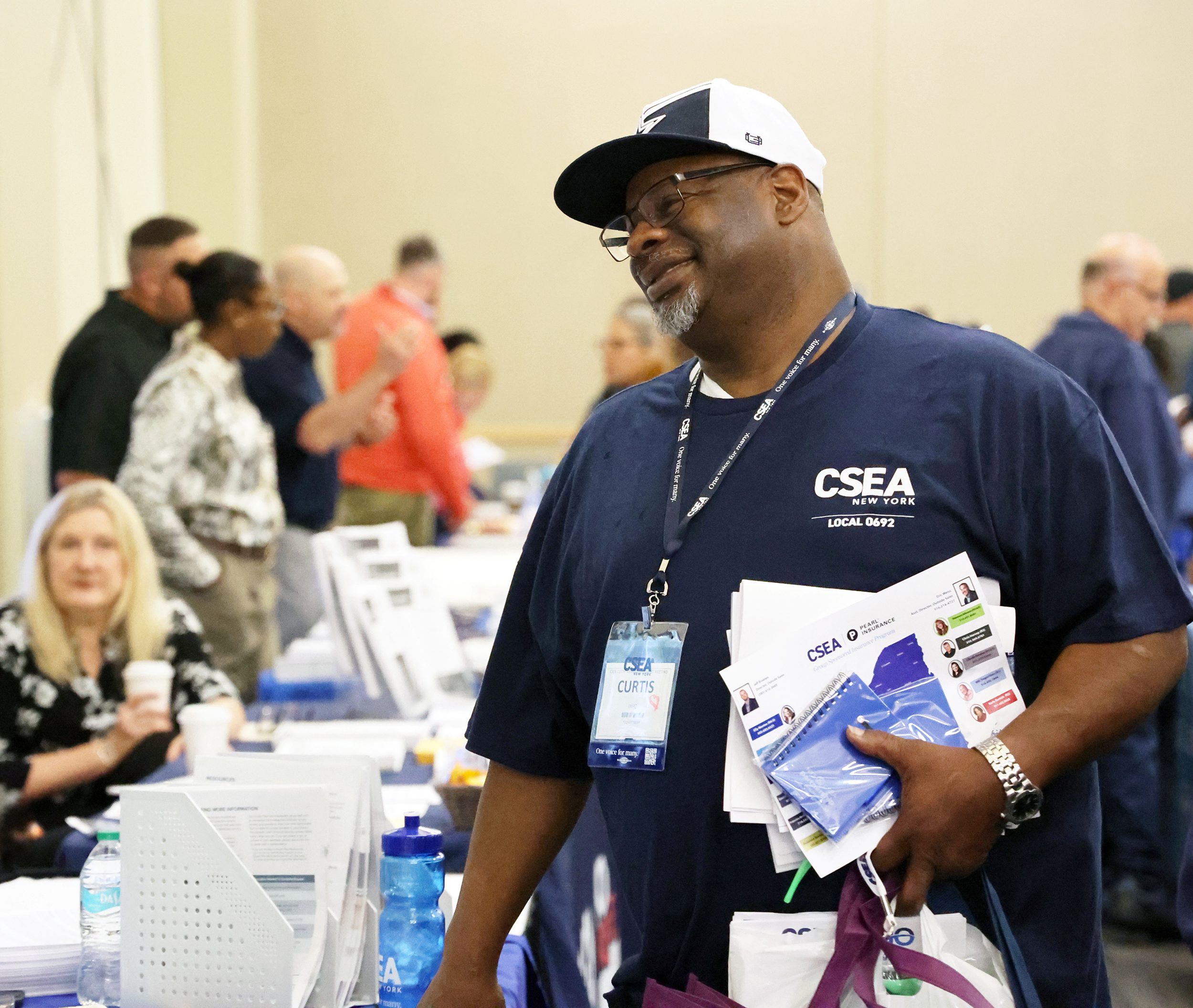 Man_standing_by_table_holding_brochures